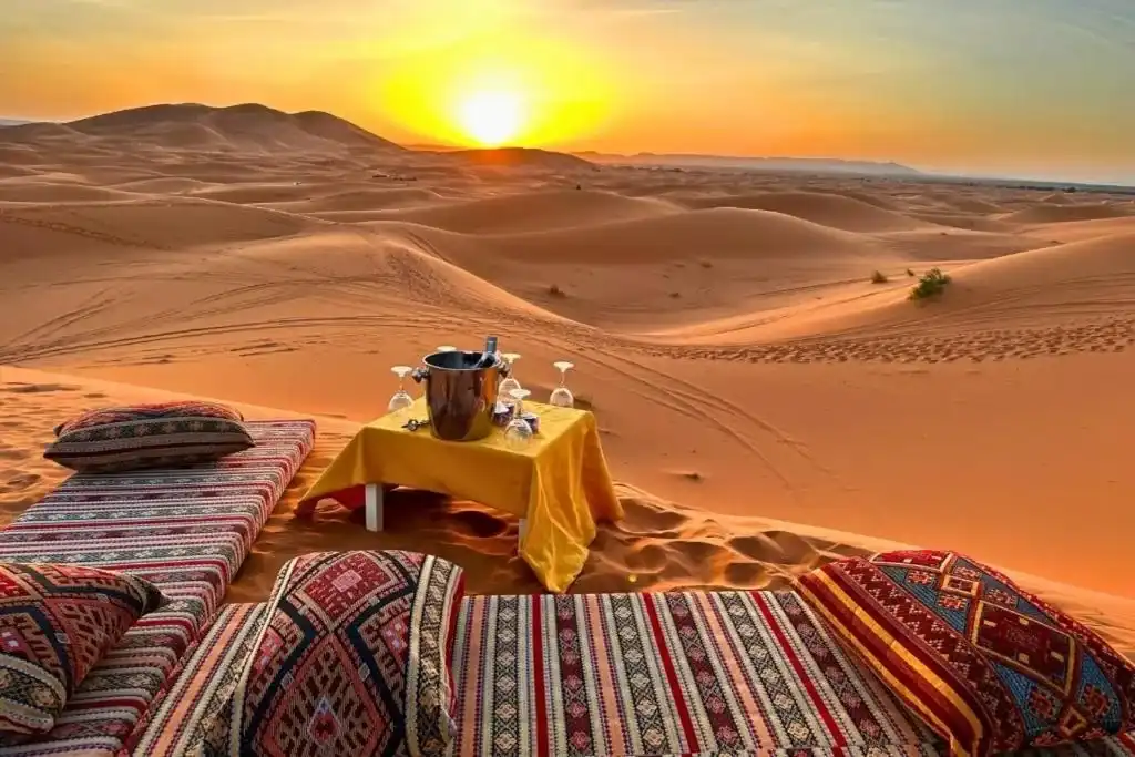 Un picnic servido sobre alfombras a la sombra cerca de las dunas de Merzouga