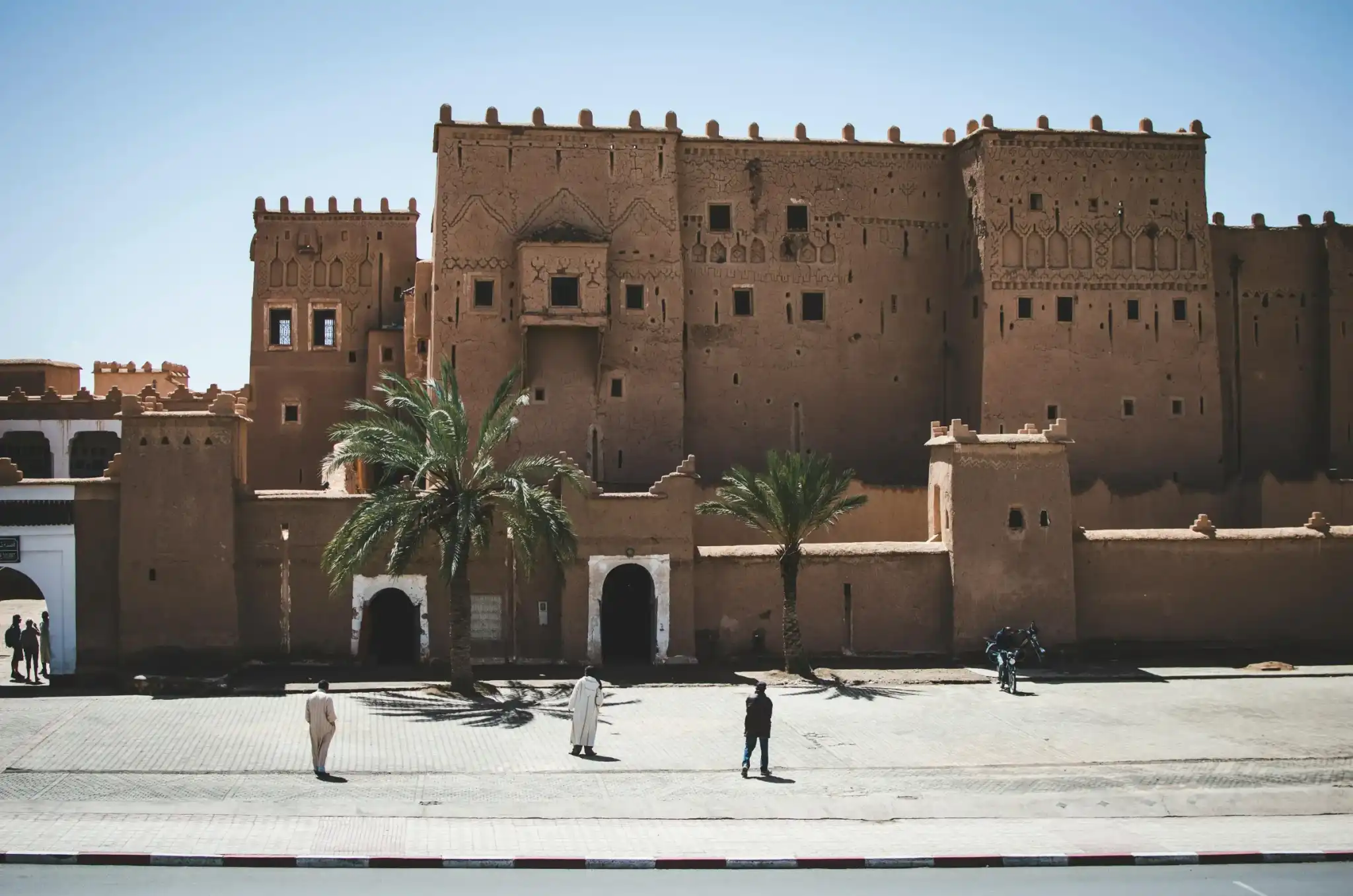 La kasbah de Taourirt à Ouarzazate, avec des palmiers devant
